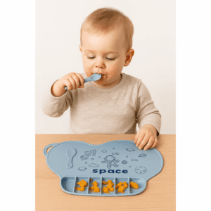 Silikonska podloga za djecu s temom svemira štiti stol, drži tanjur u mjestu i pomaže u učenju samostalnog jela. Izrađena od sigurnog silikona za hranu, ima protukliznu površinu i integrirani džep za komarice. Lako se čisti - vodootporna, ručno pranje ili perilica posuđa. Vješalica olakšava pohranu, a plava boja s kozmičkim uzorkom potiče na obroke.